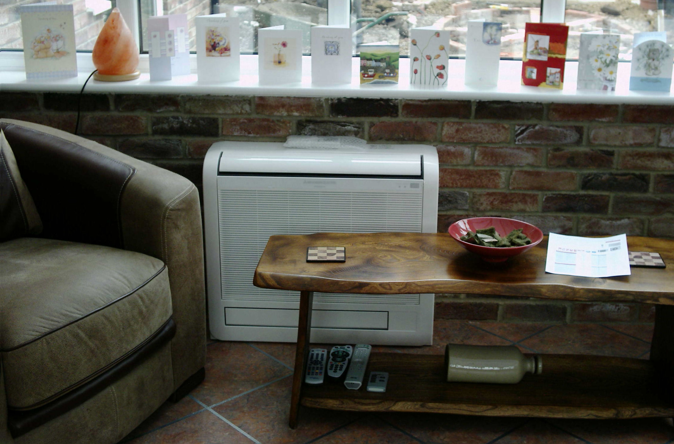 Small air conditioning unit installed next to seat and table.